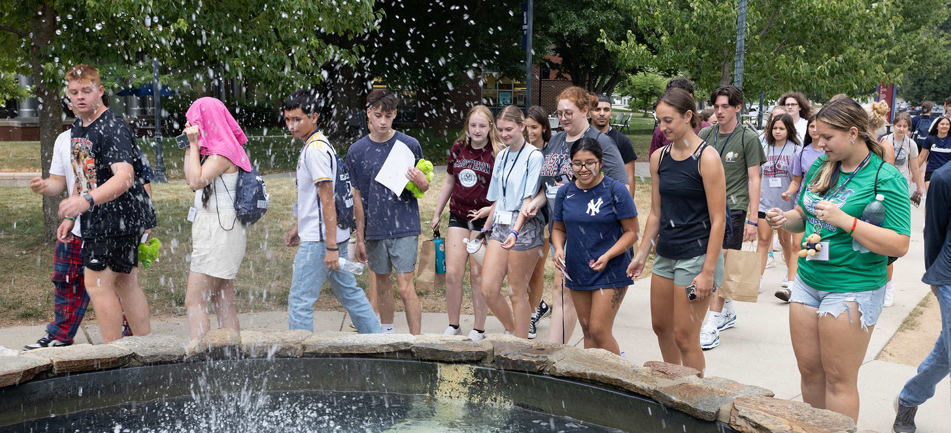 students tossing coins into a fountain