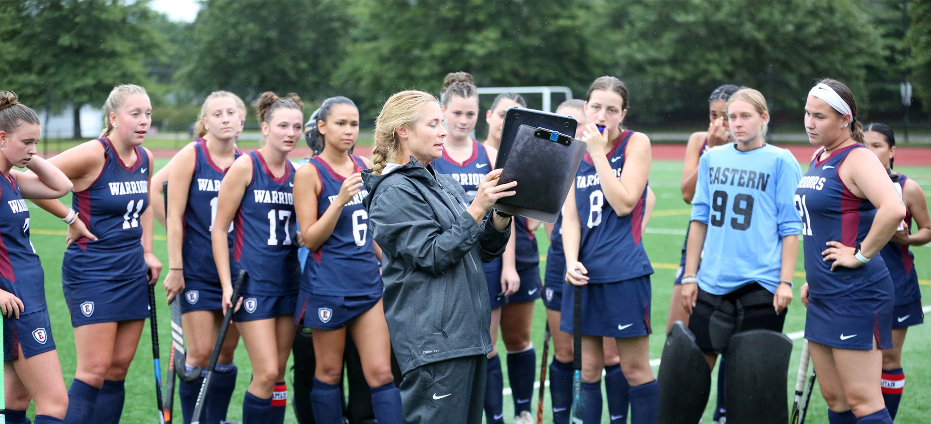 field hockey players listening to their coach