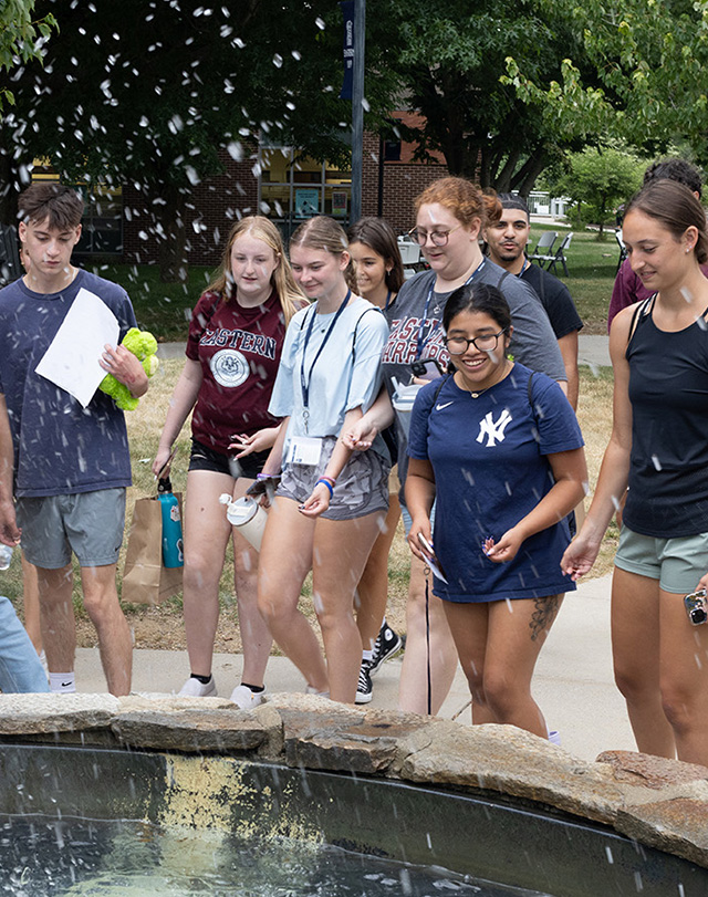 students tossing coins into a fountain