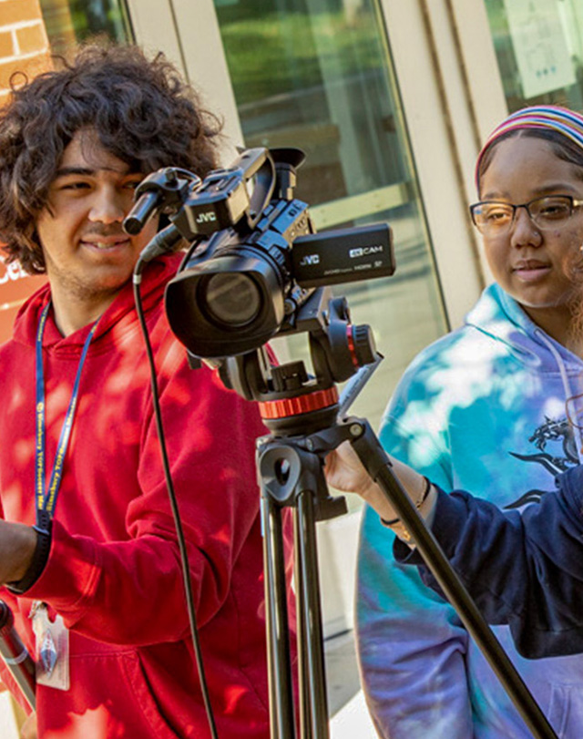 students using camera equipment outdoors