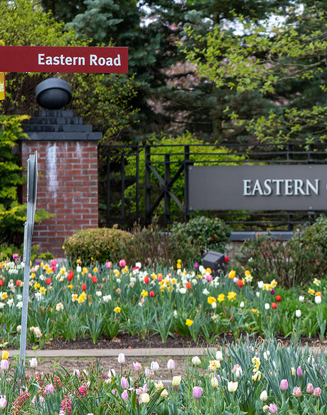 the Eastern sign at the entrance to campus with flowers around it