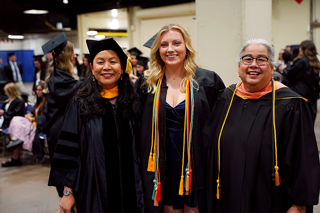 graduates in caps and gowns posing for a picture