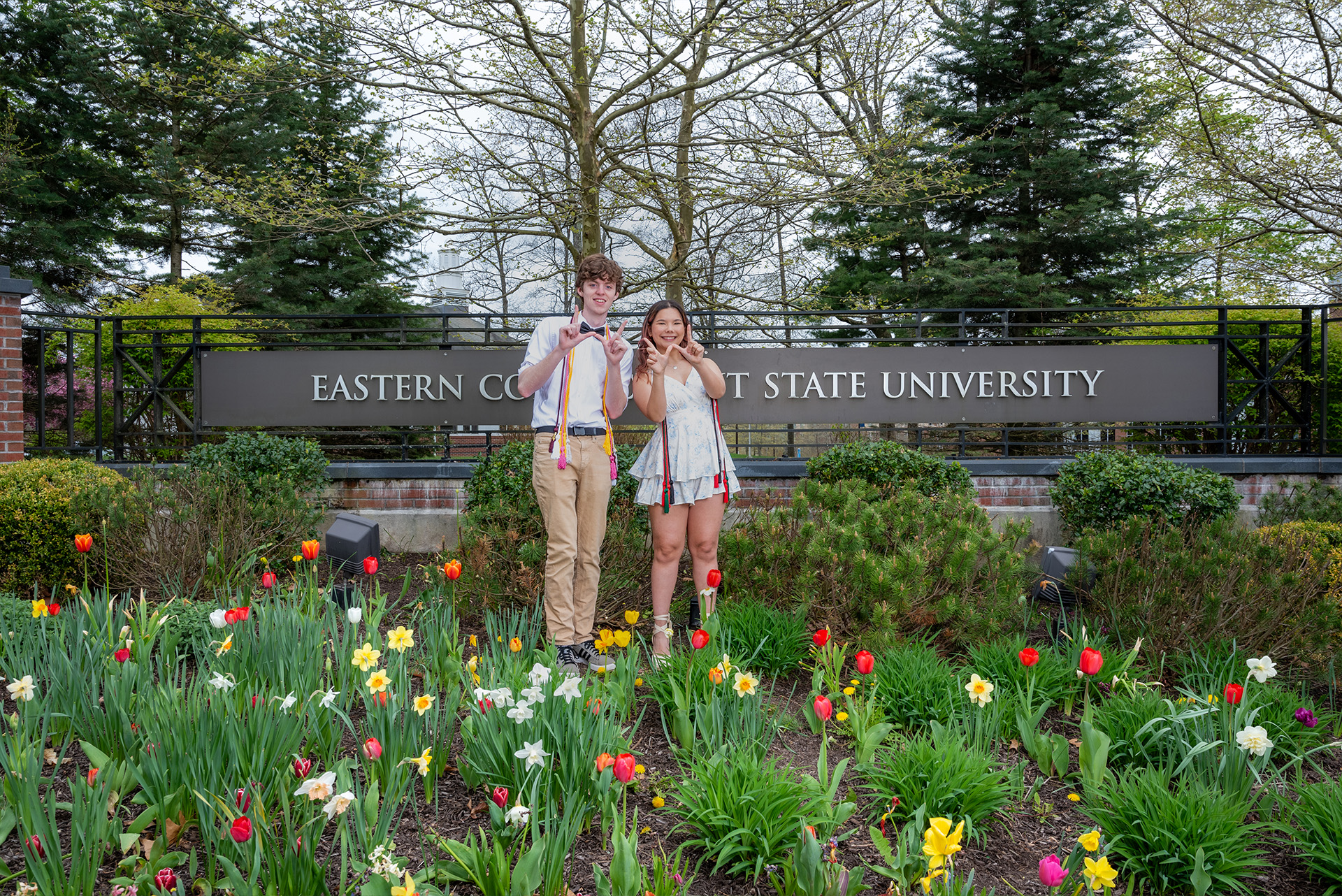 Students posing in front of Eastern's entrance sign