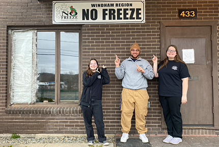 student posing for photo in front of Windham Region No Freeze Shelter