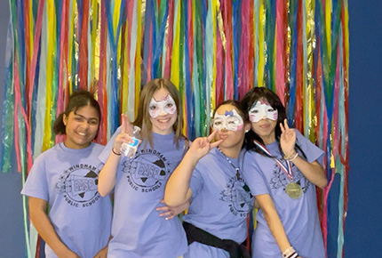 student posing for photo with masquerade masks