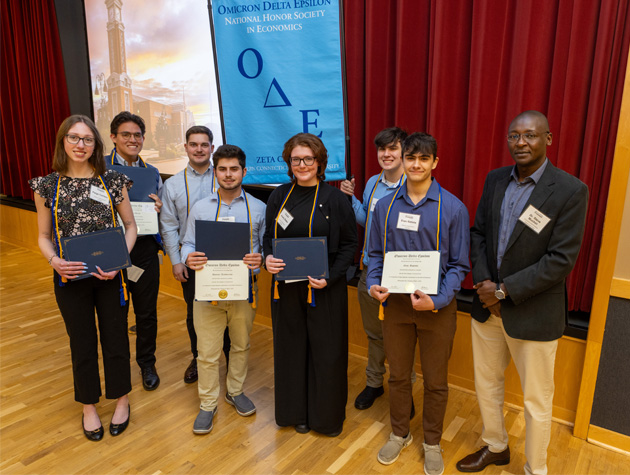 Professor posing for photo with honor society members