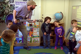 Matthew Vizzo leads a music class with children.