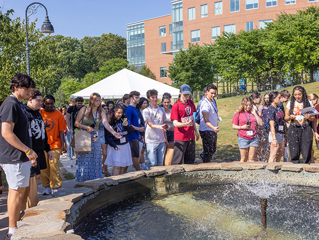 students gathered around a water fountain