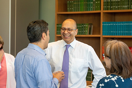 President Ismaili talking with faculty members