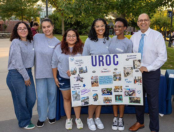 President Ismaili posing for photo with students from UROC