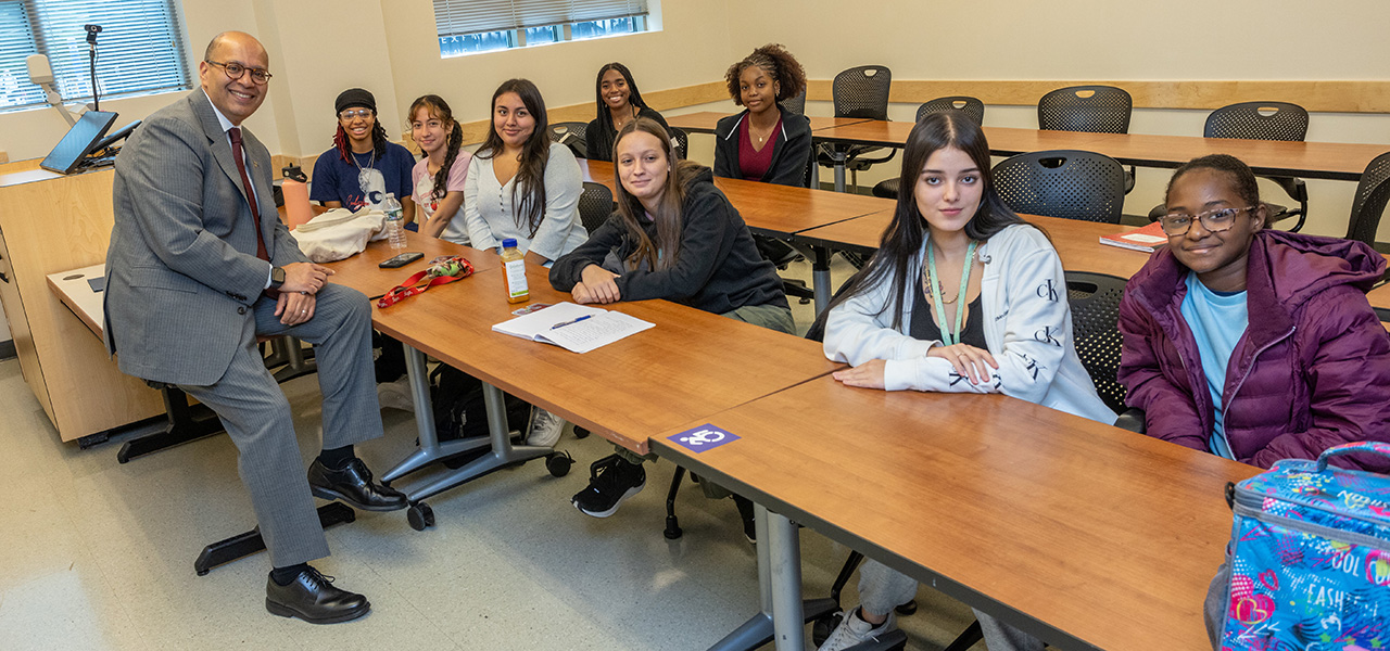 President Ismaili posing for photo with students in the classroom