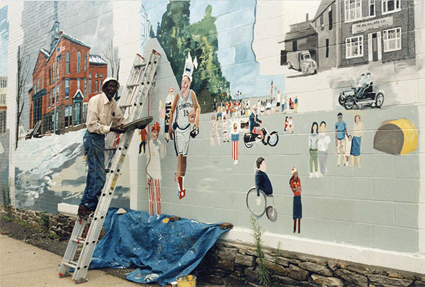 Arnold Prince painting a mural