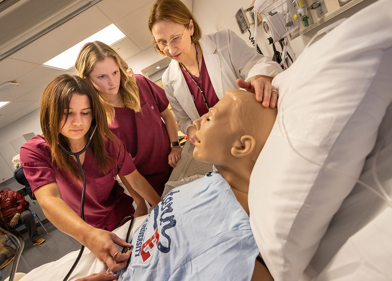 students practicing on medical dummy