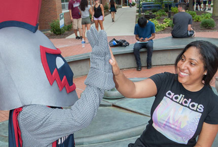 Student high-fiving Willi, the Eastern Mascot